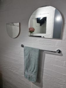 a bathroom with a mirror and a towel on a towel rack at CM Loft Maboneng in Johannesburg