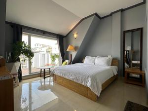 um quarto com uma cama e uma grande janela em CozyNook Boutique Apartments - 3 thang 2 Street em Da Lat