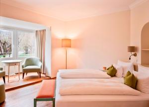 سرير أو أسرّة في غرفة في Waldhof Fuschlsee Resort