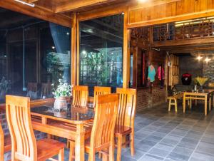 comedor con mesa de madera y sillas en Wild Apple homestay, en Sa Pả