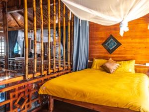 - une chambre avec un lit jaune et un mur en bois dans l'établissement Wild Apple homestay, à Sa Pả