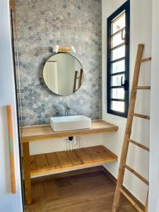 La salle de bains est pourvue d'un lavabo et d'un miroir mural. dans l'établissement Aloes - Villa Salba. Panoramic view., à L'Étang-Salé