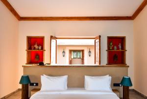 a bedroom with a large bed and a mirror at Anopura Jaipur in Jaipur