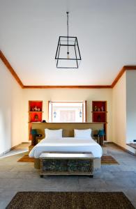 a bedroom with a large bed and a chandelier at Anopura Jaipur in Jaipur