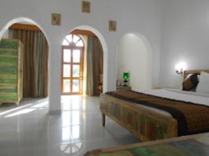 卡修拉荷的住宿－Hotel Isabel Palace, Khajuraho，一间卧室设有一张大床和一个窗户。