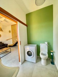 a bathroom with a washing machine and a toilet at Aloes - Villa Salba. Panoramic view. in Étang-Salé