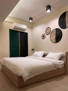 a bedroom with a large bed with a green wall at Rema residence China town in Bangkok