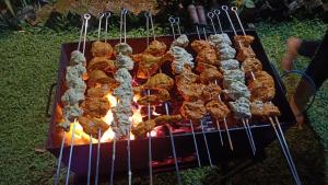 a bunch of food cooking on a grill at The Royal Ascot Holiday Home in Alibaug