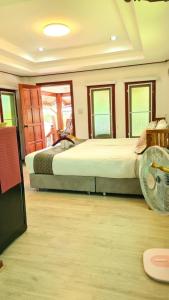 a bedroom with two beds and a fan at Lampang Hideaway Guesthouse in Lampang