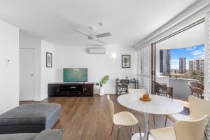Apartamento con sala de estar con mesa y TV. en Pacific Resort Broadbeach, en Gold Coast