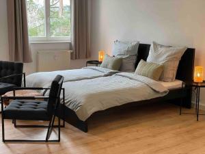 una camera con un grande letto e una sedia di cozy Apartment/WLAN in Neustadt i. Sachsen a Neustadt in Sachsen