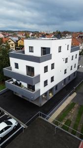 an aerial view of a white building with a parking lot at Hugo apartments in Zagreb