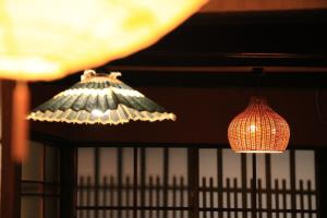 duas luzes penduradas no tecto num quarto em Kyonoyado Nijo Yumeya em Quioto