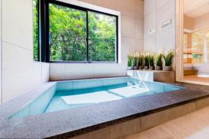 a tub in a bathroom with a window at Sakura 88 - Luxury Villa - 280sqm 4 bedrooms in Hakuba