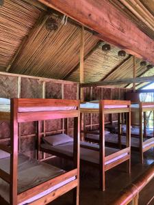a group of bunk beds in a room with a roof at Surf and Skate Duli El Nido By Kiteclub Palawan in El Nido