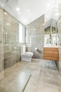 ヌーサヘッズにあるPeaceful & Stylish Retreat, Noosa Headsのトイレとガラスのシャワー付きのバスルーム +8枚の写真