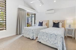 ヌーサヘッズにあるPeaceful & Stylish Retreat, Noosa Headsのベッド2台と窓のある寝室