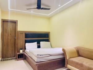 a bedroom with a bed and a couch at Hotel Himgiri Pakki Daki in Jammu