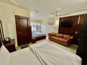 a hotel room with a bed and a couch at Hotel Himgiri Pakki Daki in Jammu