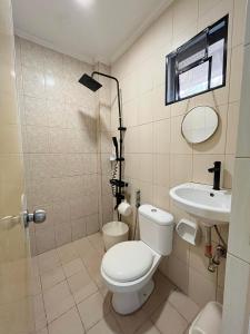 a bathroom with a toilet and a sink at Nolina's Transient Rooms - Alaminos, Pangasinan in Alaminos