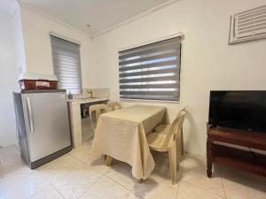 a kitchen with a table and a refrigerator and a piano at Nolina's Transient Rooms - Alaminos, Pangasinan in Alaminos