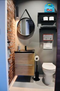a bathroom with a sink and a mirror and a toilet at Chic Penthouse industrial-style in Mosta