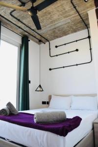 a bedroom with a large bed with purple sheets at Chic Penthouse industrial-style in Mosta