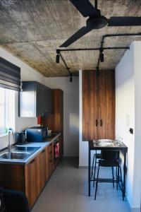 a kitchen with wooden cabinets and a table with chairs at Chic Penthouse industrial-style in Mosta