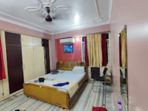 ein Schlafzimmer mit einem Bett und einem Sofa in der Unterkunft Hotel Poonam Home Stay-Best Hotel in Kankarbagh, Patna in Patna