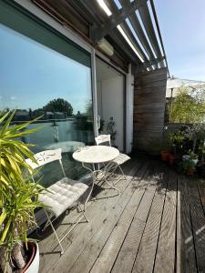 a patio with a table and chairs on a deck at Bright And Airy Islington Apartment in London