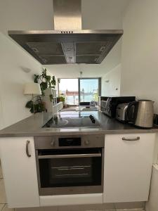 a kitchen with a sink and a stove at Bright And Airy Islington Apartment in London