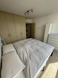 a bedroom with a large bed with white sheets at Bright And Airy Islington Apartment in London