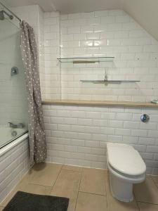 uma casa de banho com um WC, um lavatório e uma banheira em Bright And Airy Islington Apartment em Londres