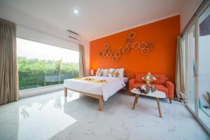 1 dormitorio con pared de color naranja, cama y sofá en Modern Cozy Private Villa with 2Br Rooftop Sunset and Vineyard View, en Banjar