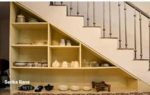 a staircase with white shelves under a stair case at White House in Canacona