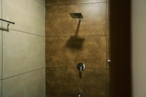 a shower with a shower head on a wall at Nature Cascade Resort in Chillithodu