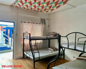 a room with two bunk beds and a colorful ceiling at Hana Natsu Resorts Beach & Hotel in Morong