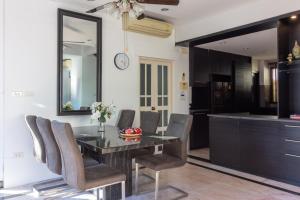 a dining room with a table and chairs and a mirror at Thabali Oasis:3BHK private pool villa + Sauna in Pattaya South