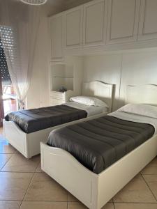 two beds in a bedroom with white walls at Luxury_C3 in Naples
