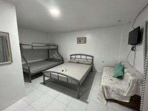 a room with two beds and a bunk bed at Nolina's Transient Rooms - Alaminos, Pangasinan in Alaminos