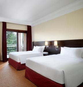 um quarto de hotel com duas camas e uma janela em Courtyard by Marriott Rome Central Park em Roma