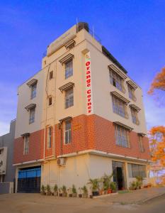 a building with a sign on the side of it at Orange Corner Hotel, MONTHLY STAY AVAILABLE in Yelahanka