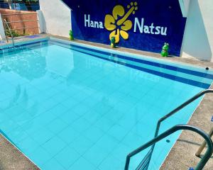 una gran piscina azul con un cartel. en Hana Natsu Resorts Beach & Hotel, en Morong