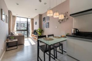 a kitchen and living room with a table in a room at Modern Condo in Nimman (F707) by Pimolplace in Chiang Mai