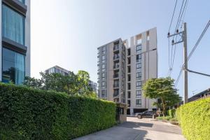 a hedge in front of a tall building at Modern Condo in Nimman (F707) by Pimolplace in Chiang Mai