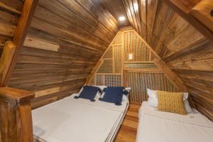 a room with two beds in a wooden attic at Camanolo Homestay in General Luna