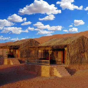 a building with straw roofs in the desert at SAMA Al Areesh Camp in Al Qābil