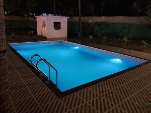 - une piscine éclairée la nuit dans l'établissement Sagar 7Bhk Villa Alibaug, à Alibaug