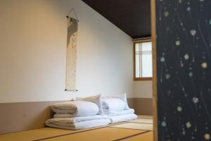 a room with a bed with white pillows on it at Guesthouse ZenNichi in Kyoto +37 photos