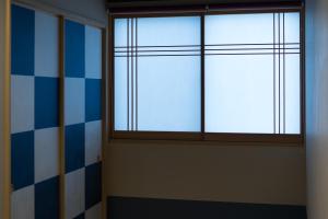 a window in a room with blue and white tiles at Guesthouse ZenNichi in Kyoto